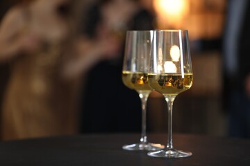 Tasty wine in glasses on black table indoors, selective focus