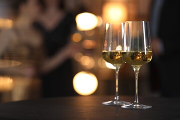 Tasty wine in glasses on black table indoors, selective focus