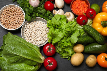 Healthy vegetarian food. Different vegetables, lentils and mushrooms on dark textured table, flat lay