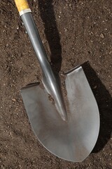 Metal shovel on pile of soil, top view