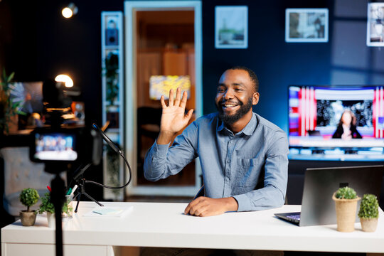 BIPOC content creator using professional recording camera and microphone to do livestream. Happy online streamer using video production gear to do live broadcast for his audience