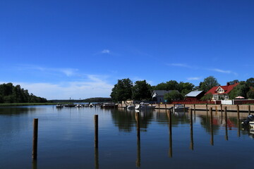Fototapeta premium Summer day at the Baltic sea. Wooden poles in blue water. Ekenäs, Finland, Europe.