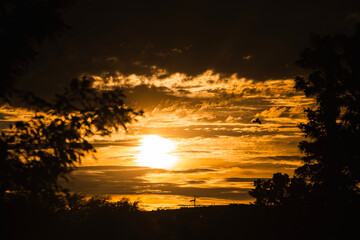 An awe-inspiring sunset with a fiery sky bursting with intense colors of red, orange, and yellow....