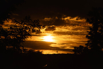 An awe-inspiring sunset with a fiery sky bursting with intense colors of red, orange, and yellow....