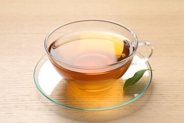 Refreshing green tea in cup on wooden table, closeup