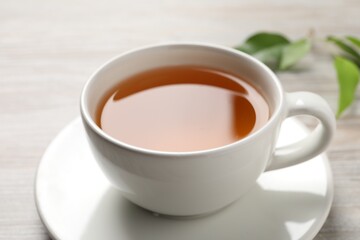 Refreshing green tea in cup on table, closeup