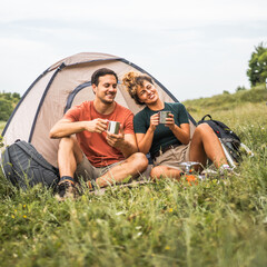 Fototapeta premium couple in love sit on the grass enjoy camp with coffee and talk