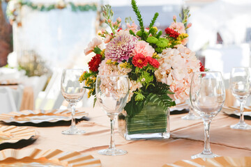 A view of a table setting at an event, featuring a beautiful flower bouquet.