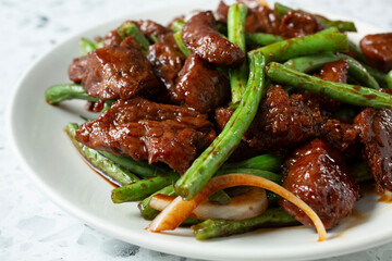 A closeup view of a plate of string bean beefsteak.