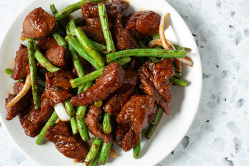 A top down view of a plate of string bean beefsteak.