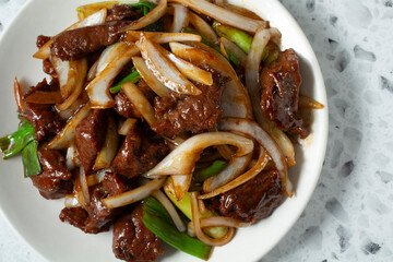 A top down view a plate of Mongolian beefsteak.