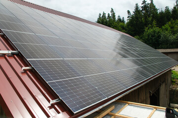 Black solar panels on a red tile roof