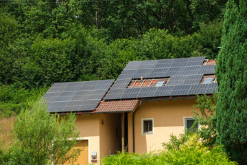 Black solar panels on a red tile roof