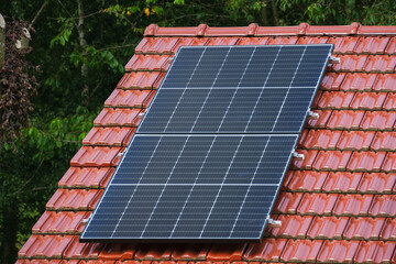 Black solar panels on a red tile roof