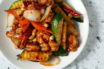A top down view of a plate of kung pao shrimp.
