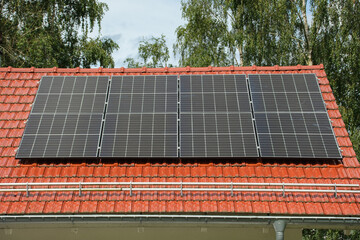 Black solar panels on a red tile roof