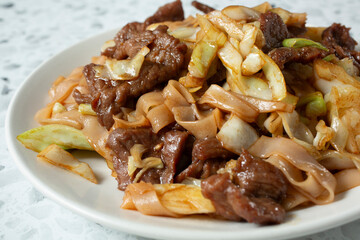 A closeup view of a plate of beef chow fun.