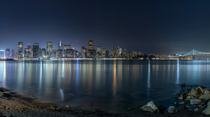 Fototapeta premium Panoramic view of San Francisco's skyline at night from Treasure Island. A startup company is launching a project to find and develop a successful business model for holograms.