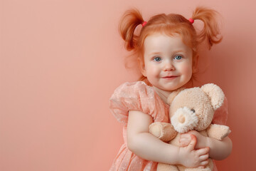 joyful young girl with ginger hair hugging a teddy bear on a soft pink background