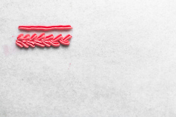 Pink buttercream piped on a granite countertop, buttercream piped using a piping tip on a white countertop