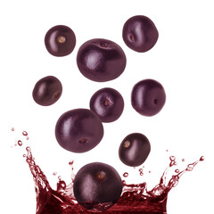 Acai berries falling into juice on white background
