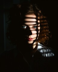 a woman in the dark with blinds on her eyes