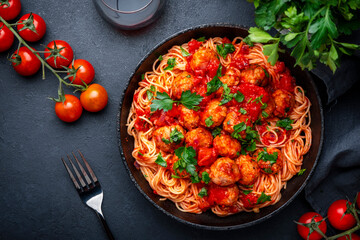 Italian spaghetti in bolognese sauce with meatballs, black table background, top view