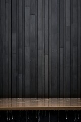 a wooden bench in front of a black wall