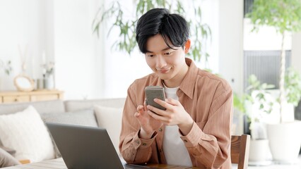 パソコンとスマートフォンを使う男性