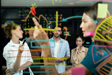 Group of smart diverse businesspeople brainstorming business strategy. Young female leader sharing, explaining, designing business idea at night office. Business planing, Working together. Tracery.
