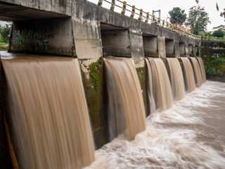 Obraz premium a murky waterfall beneath a bridge that serves as a dam