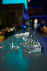Numerous small glass shards scattered across a bar counter in a dimly lit setting