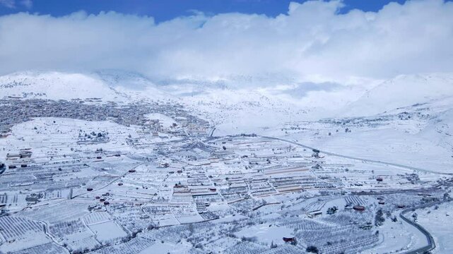 Aerial Forward Scenic Shot Of Snow Covered Golan Heights Under Clouds In Sky - Majdal Shams, Israel