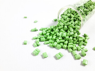 Matcha green masterbatch granules with glass tube on white background.Color pigment carrier polymer...