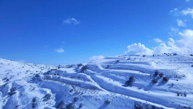 Aerial Backward Panning Shot Of Tranquil Snow Covered Mount Hermon Range On Sunny Day - Majdal Shams, Israel