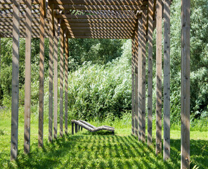 wooden gazebo in the park with sun loungers, summer landscape.