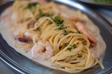 White wine cream sauce prawn and bacon pasta spaghetti served on plate