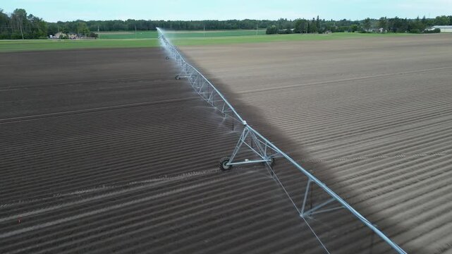 aerial view of a boom irrigation system in action in a field - vue a&eacute;rienne d'un syst&egrave;me d'irrigation par rampe en action dans un champ
