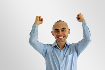 Young happy businessman celebrating with hands up and big smile