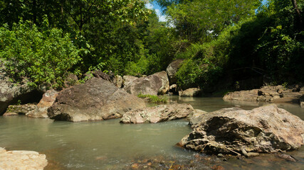 The flow of river water with large rocks looks natural from the upstream of the river