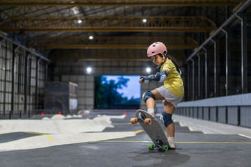 skater asian child or kid girl play skateboard or ride surf skate and ollie jumping fun or lifting...