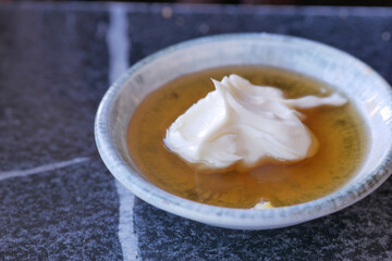 butter cream and honey in a bowl on table .