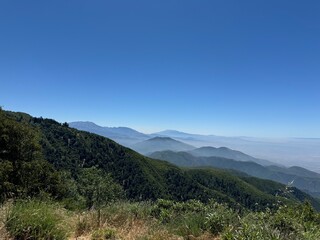 an incredible beautiful panorama vista landscape photo of green mountains and mist beneath a...