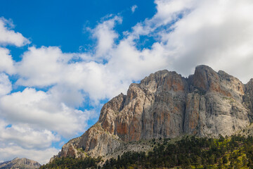 Mountains in the clouds. View of the mountain peak in the fog. Beautiful landscape with high cliffs. Dedegol. Turkey.