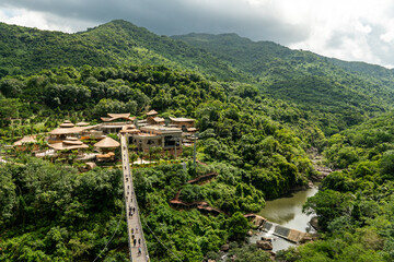 A national park in the center of Hainan Island, China. long suspended wooden bridge in forest park...