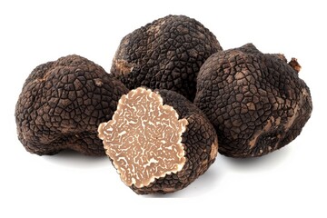 whole black truffles with a few several thin slices arranged around it isolated on a white background. 