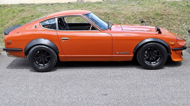 Azzida, Italy. July, 6 2024. Orange Datsun Fairlady Z, also known as Nissan Z during a classic car gathering. It is  a japanase sports car from late Sixties and  the Seventies.