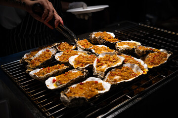Street food at a night market in Sanya, Hainan Island in China.. Grill oyster in the street market