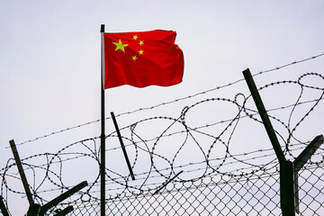 The concept of sanctions pressure on the China government. Chinese flag in barbed wire, sanctions...