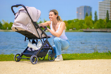 Happy Mother with Baby Stroller near Lake